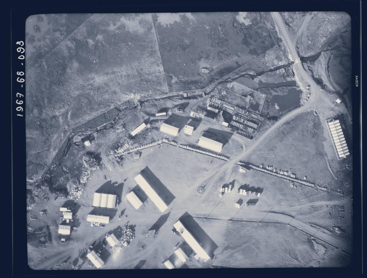 Photographie aérienne de la base de Port-aux-Français, aux Kerguelen, prise par l'IGN en 1967 ; le bord de la pellicule porte le numéro du cliché.